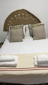 a bed with a wooden headboard with pillows at Feel Welcome Barcelona 10 in Cornellà de Llobregat