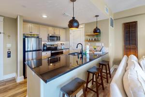 a kitchen with a bar with a sink and a couch at Grand Sandestin 2422 in Destin