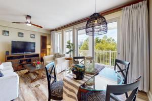 a living room with a table and chairs and a television at Grand Sandestin 2422 in Destin