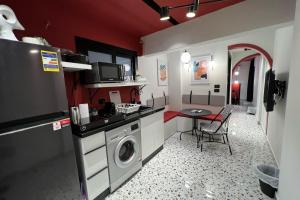 una cucina con lavatrice e tavolo di The 1 BDR Ruby Flatette 5 min to CAI Airport a Il Cairo