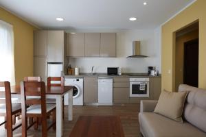 a kitchen and living room with a table and a couch at Apartamentos Rurales Casa la Piedra in Collía +37 photos