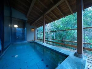 an indoor swimming pool in a house with a balcony at Musashino Bekkan in Hakone