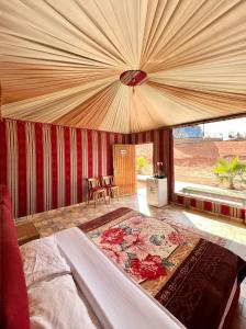 a bedroom with a bed with a large canopy at Tamim Luxury wadi rum camp in Wadi Rum