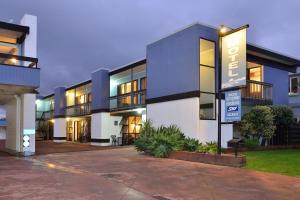 a building with a sign in front of it at Waikanae Beach Motel in Gisborne