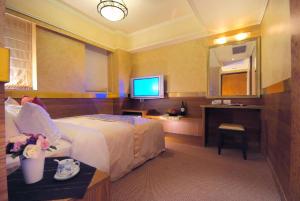 a hotel room with a bed and a flat screen tv at Lio Hotel - Taipei Main Station in Taipei