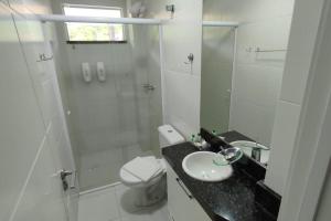 a bathroom with a toilet and a sink and a shower at 122-Alquiler Deptos Complejo SummerBeach Bombinhas in Bombinhas +13 photos