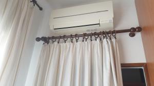 a room with a curtain and a air conditioner at Apolloni di Loano appartamento privato - Codici Citra visibili su STRUTTURA in Loano