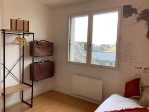 Zimmer mit einem Bett, einem Fenster und einem Regal in der Unterkunft Un voyage à Bourgeuil in Bourgueil