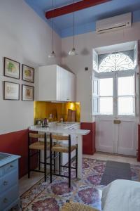 a kitchen with a kitchen island with chairs and a window at Central Malta Luxe Suite Prime Location in Mosta +31 photos