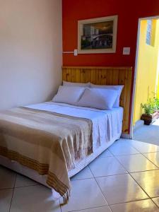 1 dormitorio con 1 cama con pared roja en Aconchego Mineiro com Garagem, en Belo Horizonte