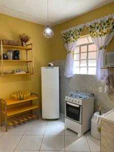 a kitchen with a refrigerator and a stove at Aconchego Mineiro com Garagem in Belo Horizonte