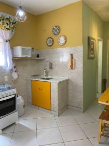 uma cozinha com um lavatório e uma bancada em Aconchego Mineiro com Garagem em Belo Horizonte