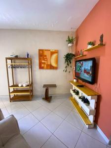 a living room with a tv on a wall at Aconchego Mineiro com Garagem in Belo Horizonte