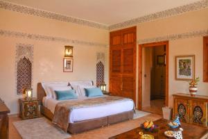 - une chambre avec un grand lit et une table dans l'établissement Dar Arraha Ouirgane, à Ouirgane