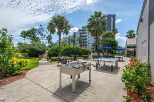 a patio with ping pong tables and palm trees at Universal Studios. Amazing 2 bedroom apartment! in Orlando