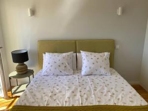 1 cama con edredón blanco y 2 almohadas en Sweet Home Clerigos City View, en Oporto