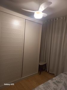 a bedroom with a ceiling fan and a sliding closet door at Aptoaconchegantepoa in Porto Alegre