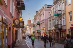 a group of people walking down a street at Charming apartment next to the Church of St Anne by Reside Baltic in Vilnius