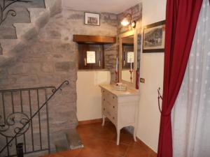 a bathroom with a sink and a stone wall at Torre Riva Dimora storica in Fiumalbo