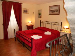 a bedroom with a red bed with two towels on it at Torre Riva Dimora storica in Fiumalbo