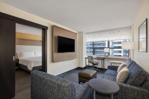 a hotel room with a bed and a living room at Holiday Inn Toronto Downtown Centre, an IHG Hotel in Toronto