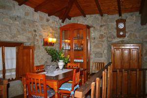 comedor con mesa, sillas y reloj en Casa Da Rocha, en Caldelas