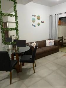 a living room with a couch and a glass table at Aconchegante Casa de praia in Matinhos