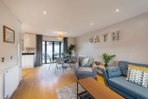 uma sala de estar com um sofá azul e uma mesa em Fantastic 3-bed house with parking em Bath