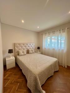 a bedroom with a large bed and a window at Nell&And&Jess HOME in Espinho