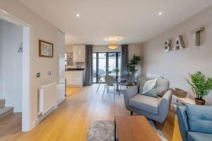 a living room with a couch and chairs and a kitchen at Fantastic 3-bed house with parking in Bath