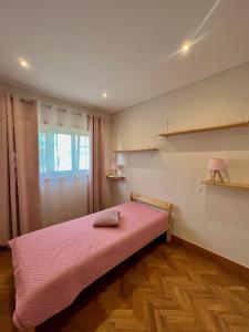 1 dormitorio con cama rosa y ventana en Nell&And&Jess HOME en Espinho