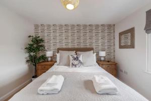 1 dormitorio con 1 cama con 2 toallas en Fantastic 3-bed house with parking, en Bath