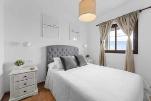 a white bedroom with a bed and a window at HOLYHOME SunSplash in Costa Teguise +11 photos