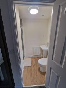 uma casa de banho com um WC branco e um lavatório. em Comfy 3 bed home em Nottingham