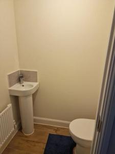 a bathroom with a toilet and a sink at Comfy 3 bed home in Nottingham