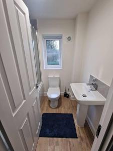 a bathroom with a white toilet and a sink at Comfy 3 bed home in Nottingham