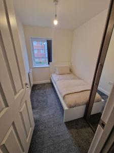 a small room with two beds and a window at Comfy 3 bed home in Nottingham