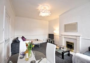 een woonkamer met een bank en een open haard bij Whifflet Apartment by Klass Living Coatbridge in Coatbridge