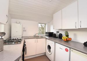a kitchen with white cabinets and a sink and a dishwasher at Whifflet Apartment by Klass Living Coatbridge in Coatbridge