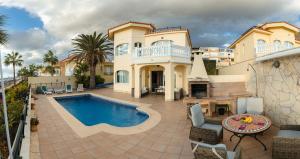 una grande casa con una piscina di fronte di Villa Faya Ocean View With Private Pool a Los Cristianos