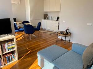 Una sala de estar con un sofá azul y una mesa. en Sweet Home Clerigos Balcony View, en Oporto
