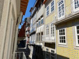un callejón entre dos edificios con baldosas amarillas y azules en Sweet Home Clerigos Balcony View, en Oporto