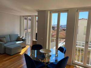 Una sala de estar con una mesa de cristal y sillas. en Sweet Home Clerigos Balcony View, en Oporto