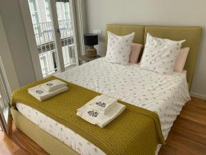 Un dormitorio con una cama grande con toallas. en Sweet Home Clerigos Balcony View, en Oporto