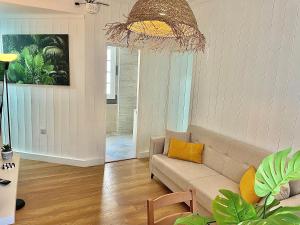 a living room with a couch and a chandelier at Las Brisas 1 by SunHousescanarias in Las Palmas de Gran Canaria