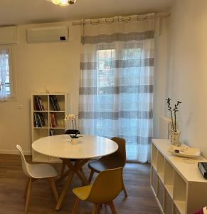 a dining room with a table and chairs and a window at Casa Marilù in Bologna