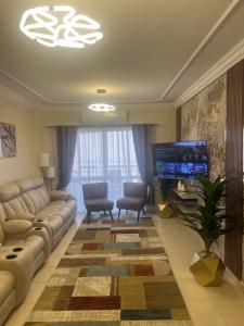 a living room with a couch and a flat screen tv at Luxurious VIP apartment in Madinaty furnished with high end hotel furniture in Madinaty