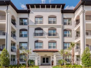 a large white building with windows and trees at NEW Amazing 3 Bedroom Apartment Vista Cay Resort in Orlando