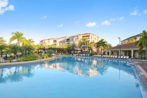 a large swimming pool at a resort with palm trees at NEW Amazing 3 Bedroom Apartment Vista Cay Resort in Orlando