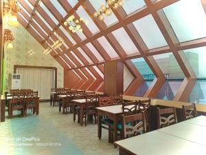 uma sala de jantar com mesas e cadeiras de madeira em Hotel KUBER PALACE ! PURI near-sea-beach-and-temple fully-air-conditioned-hotel with-lift-and-parking-facility em Puri